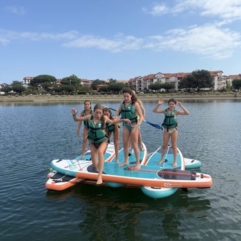 Groupe d'adolescentes sur un Big Paddle XXL dans la baie d'Hendaye